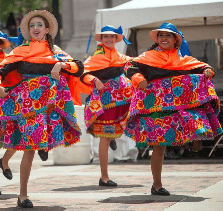 Three ladies in native costume dancing at Festival
